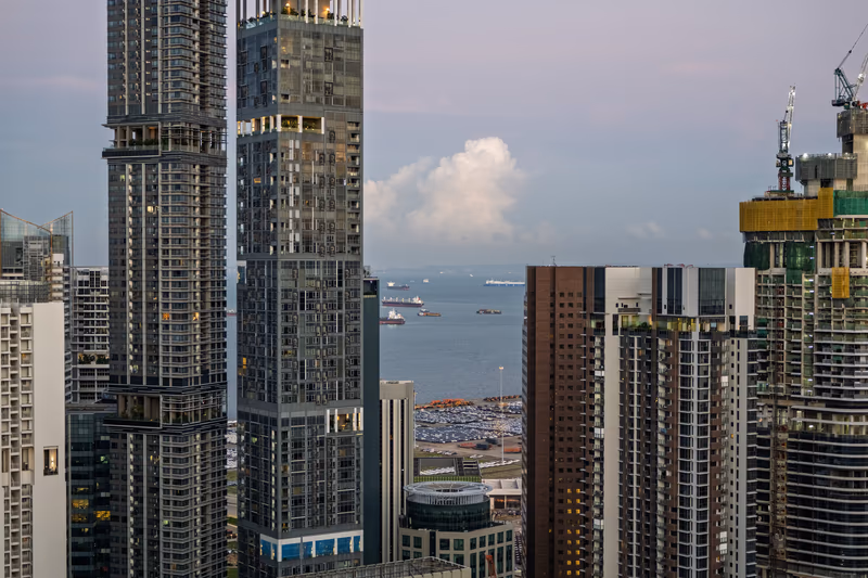 摩天大楼高耸入云，俯瞰海港的点点船只