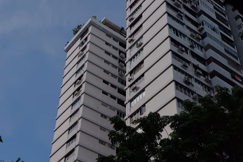 仰角视角的白色公寓楼群，外墙密布着空调外机