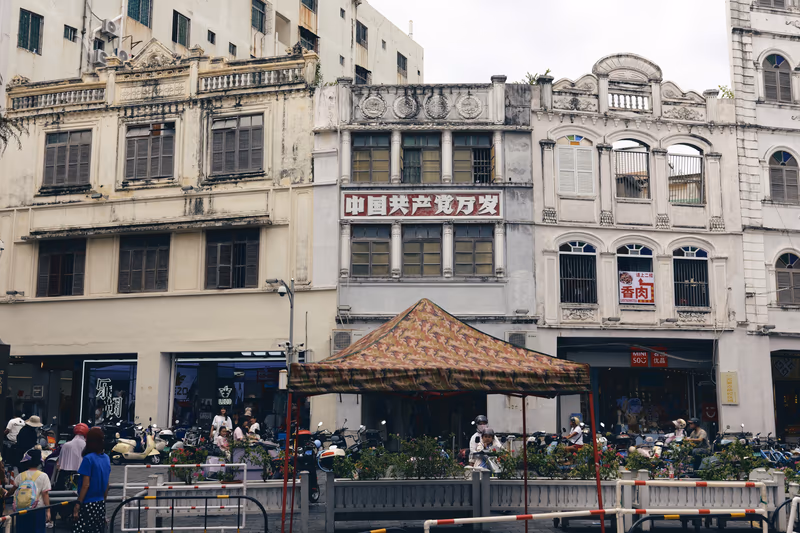 老建筑前彩色帐篷与停放摩托