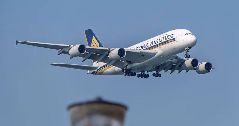 新加坡航空 A380-800 9V-SKU 掠过，前景水塔虚化