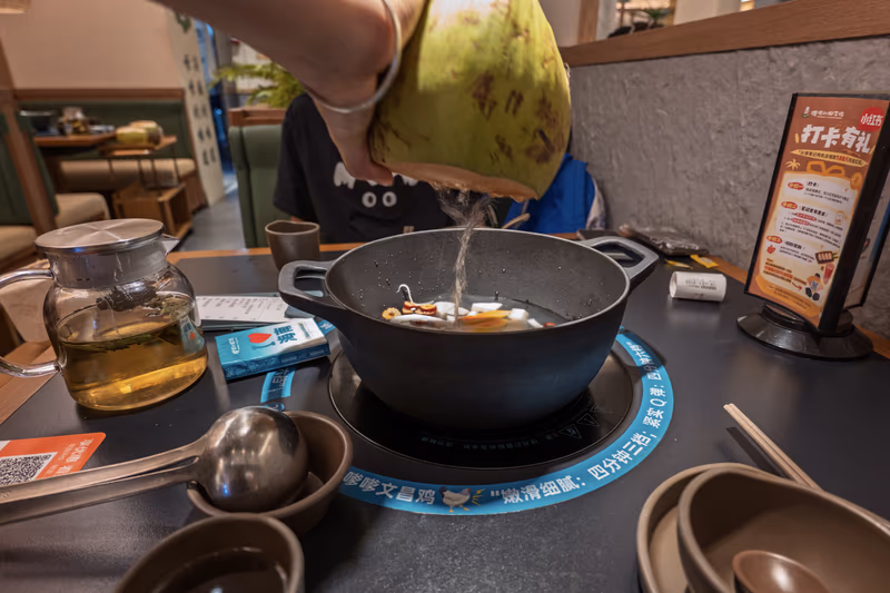 手持青椰倾倒汁液入锅